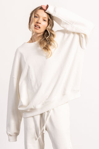 Blonde female model wearing a white crewneck sweatshirt