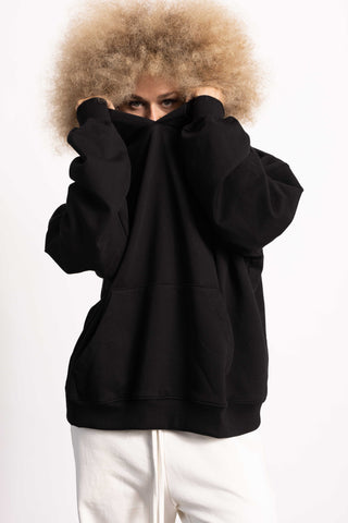 White female model wearing a black Drop Shoulder Pima Cotton Hoodie