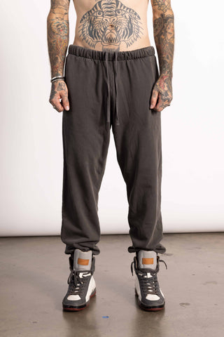 White edgy male model wearing dark brown sweatpants