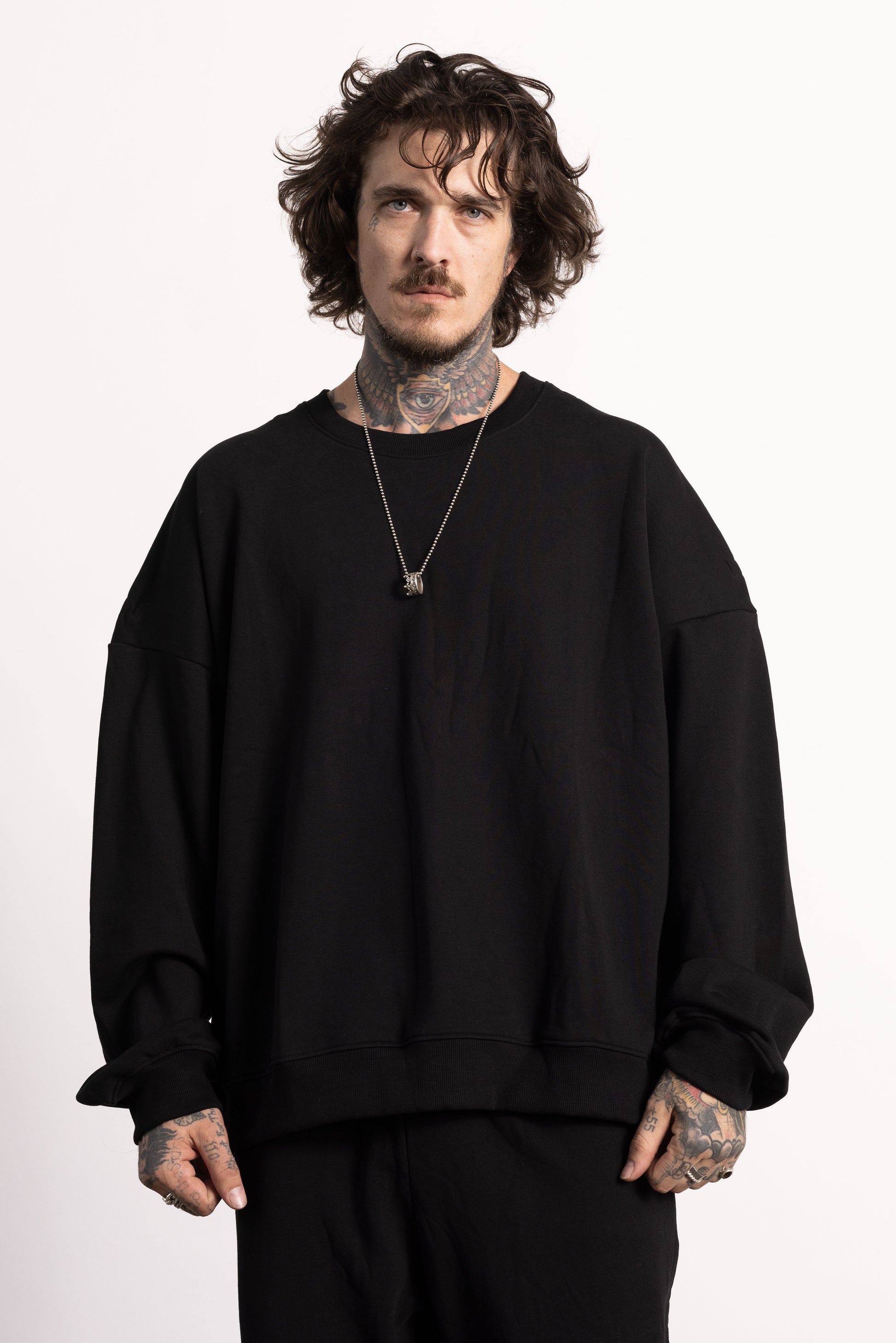 white edgy model with tattoos wearing a drop shoulder sweatshirt