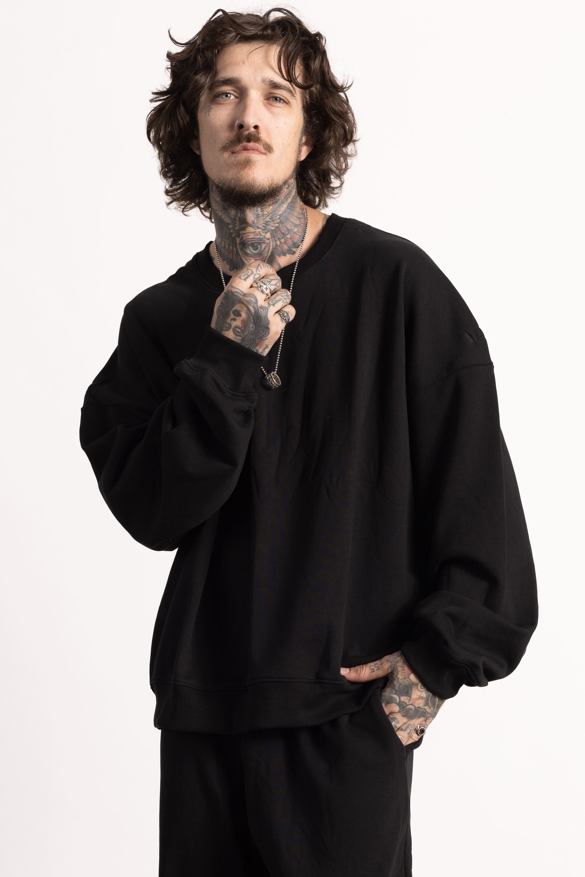 white edgy model with tattoos wearing a drop shoulder sweatshirt